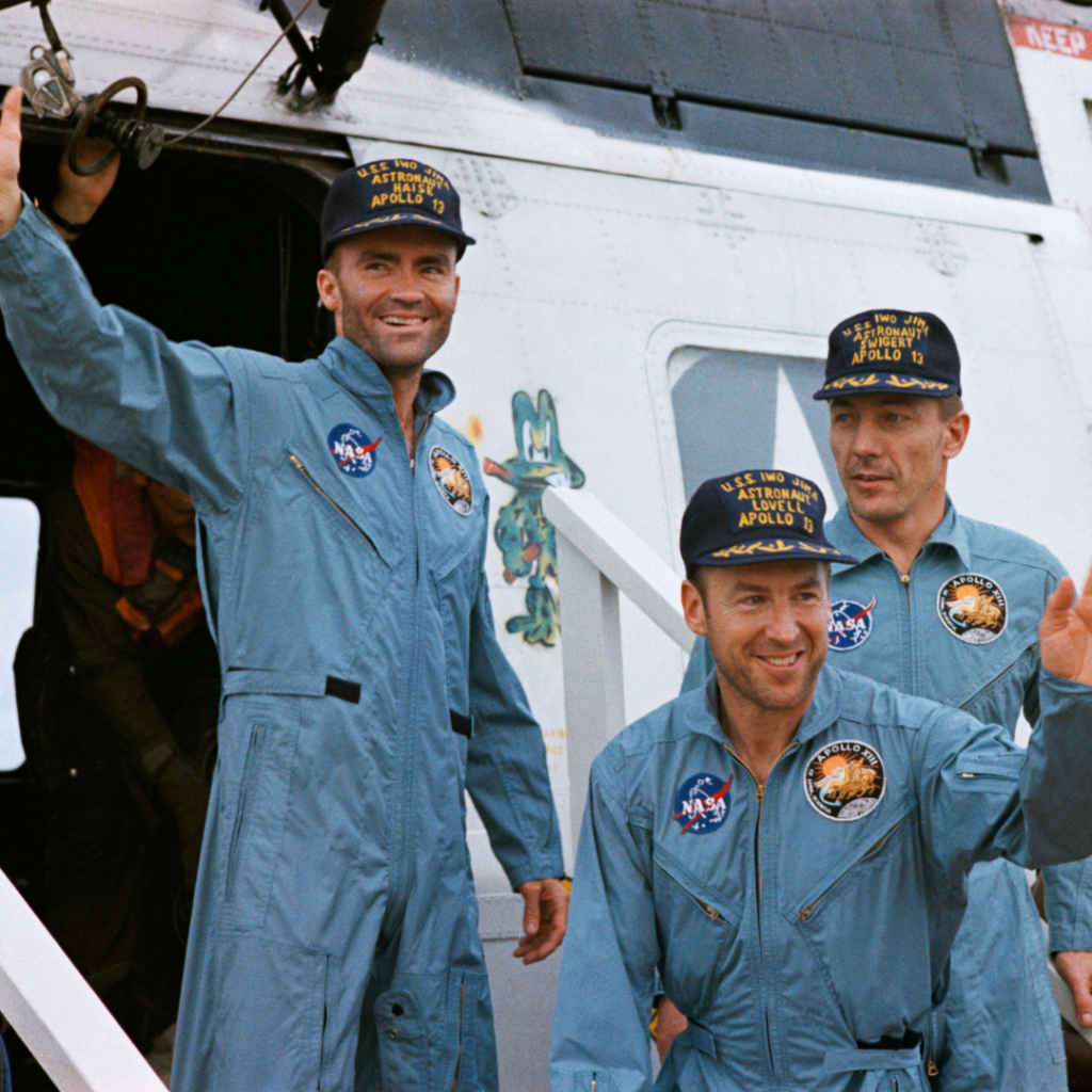 Fred Haise (left), Jim Lovell, and Jack Swigert emerge from the recovery helicopter on-board the aircraft carrier Iwo Jima. 17 April 1970. Scan by Ed Hengeveld.